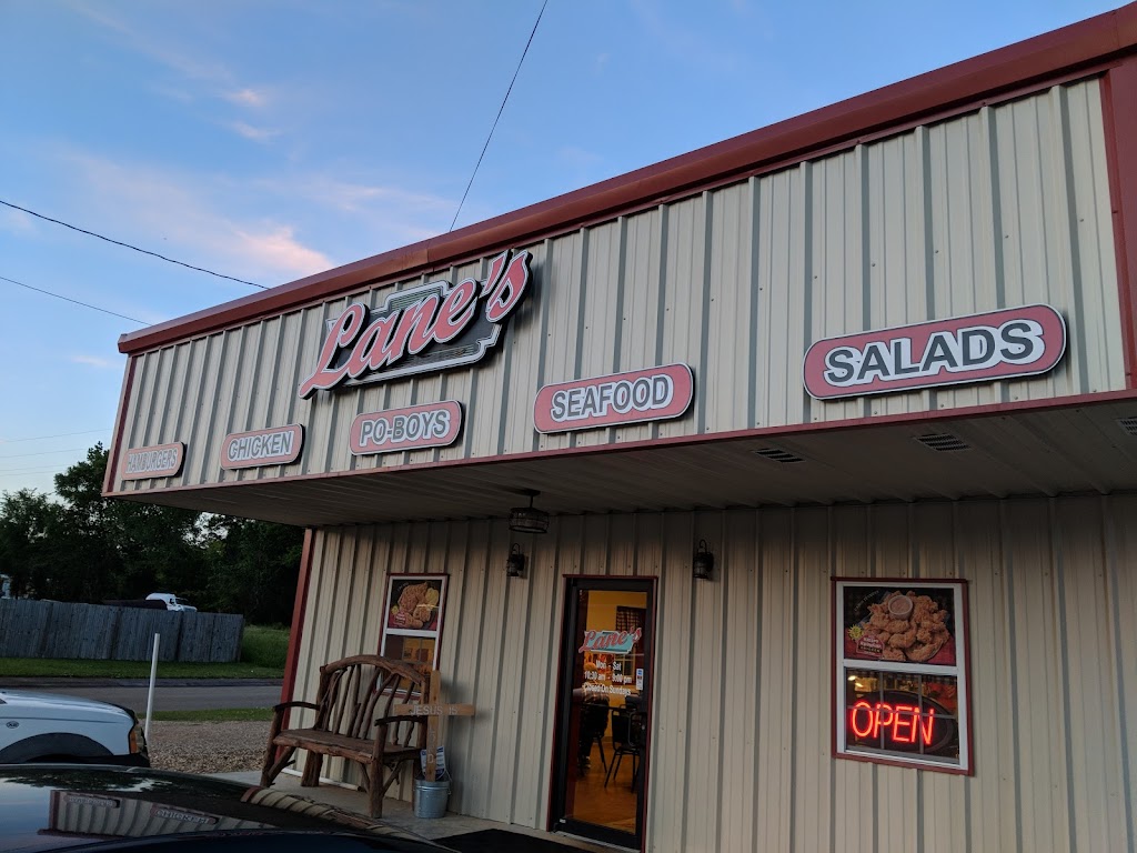 Lane's storefront with hamburgers, chicken, po-boys, seafood and salads on the facade and a neon open sign