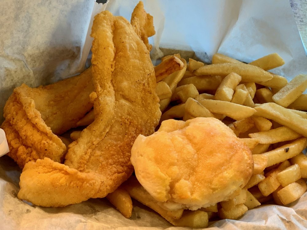 Fried fish filets and french fries in a paper-lined basket